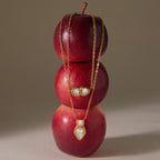 Both pendant designs displayed on stacked red apples