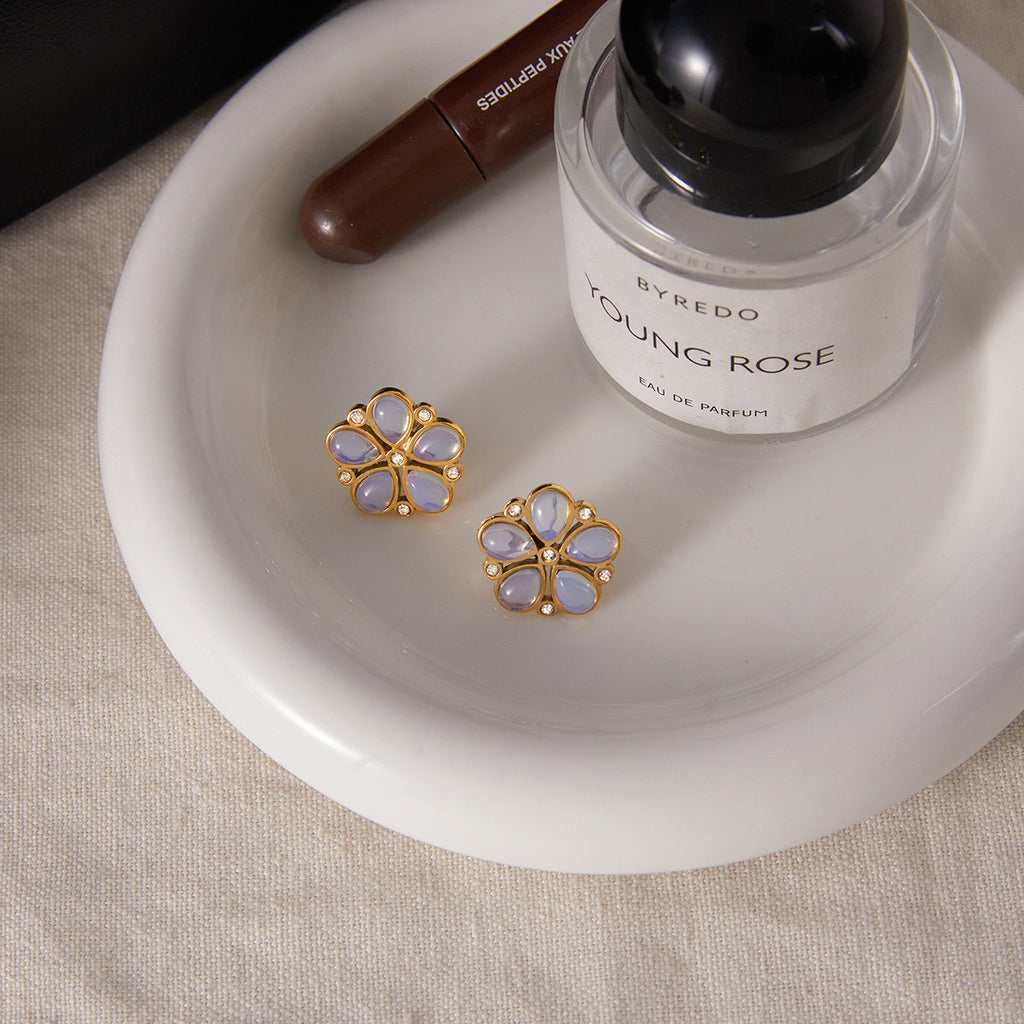 gold plated floral studs with pearlescent petals on a tray