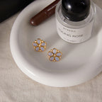 gold plated floral studs with pearlescent petals on a tray
