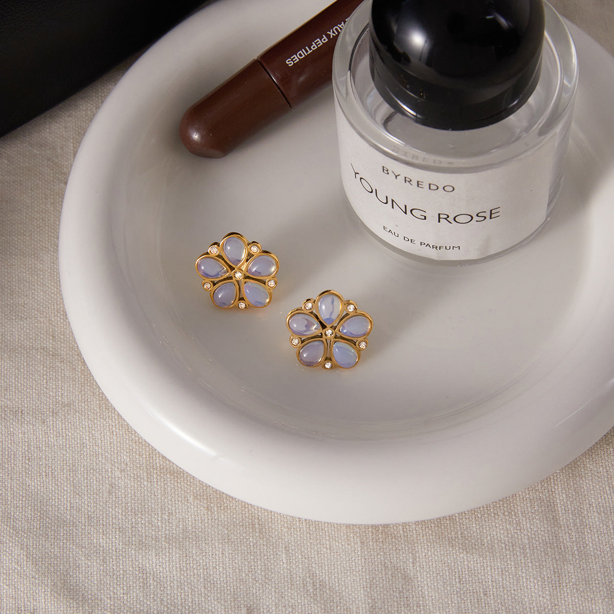 gold plated floral studs with pearlescent petals on a tray
