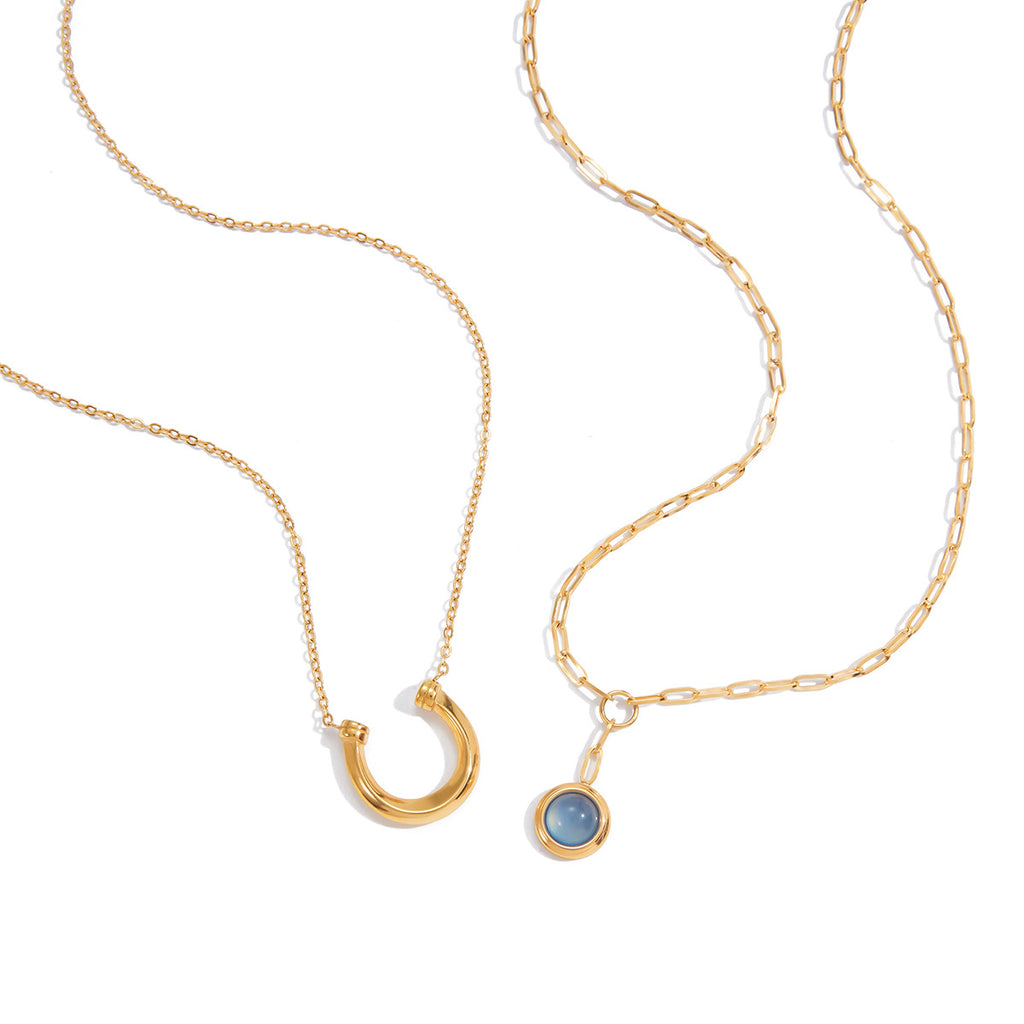Gold Tone Blue Cabochon Stainless Steel Equestrian Necklaces — close-up of the crescent pendant