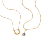 Gold Tone Blue Cabochon Stainless Steel Equestrian Necklaces — close-up of the crescent pendant