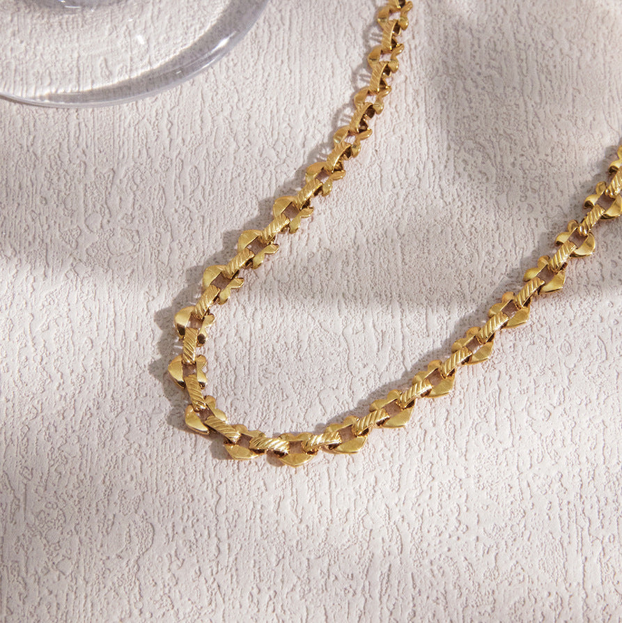 Heart-link chain laid across textured fabric