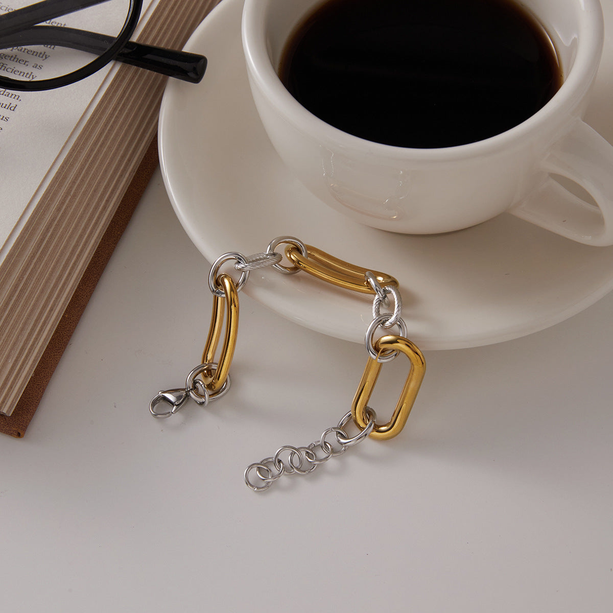 Full bracelet showing clasp and extender beside a cup