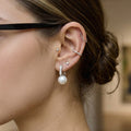 model wearing silver-finish resin pearl huggie earrings