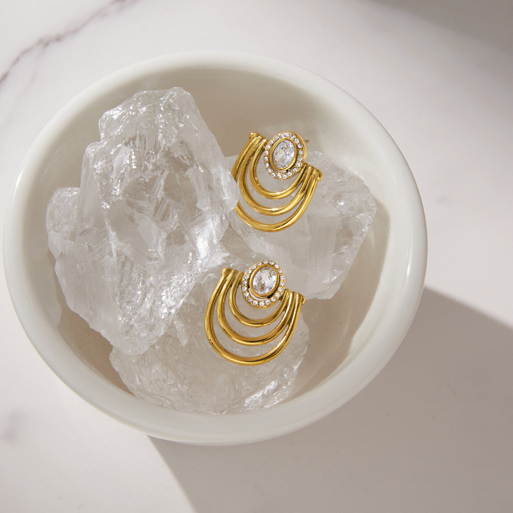 Pair of arc earrings displayed on clear stones