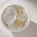 Pair of arc earrings displayed on clear stones