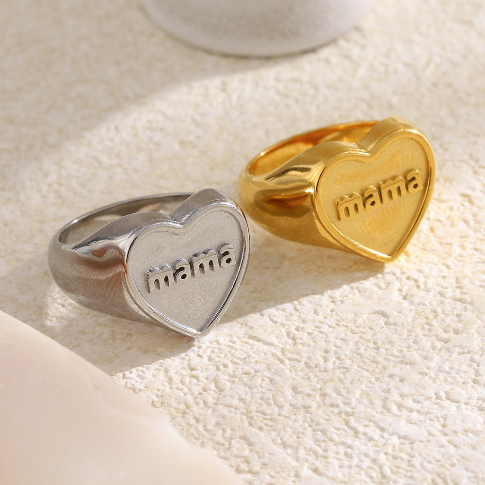 gold and silver mama heart signet rings on a textured surface