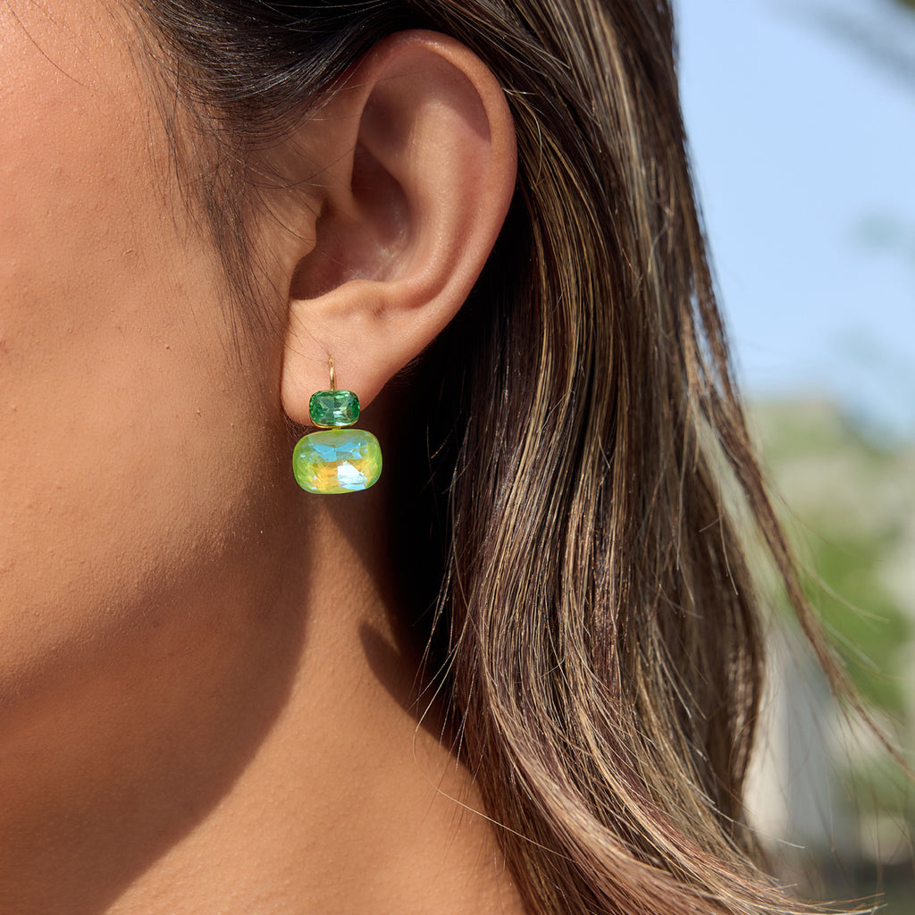 Green two-stone leverback earring worn on ear