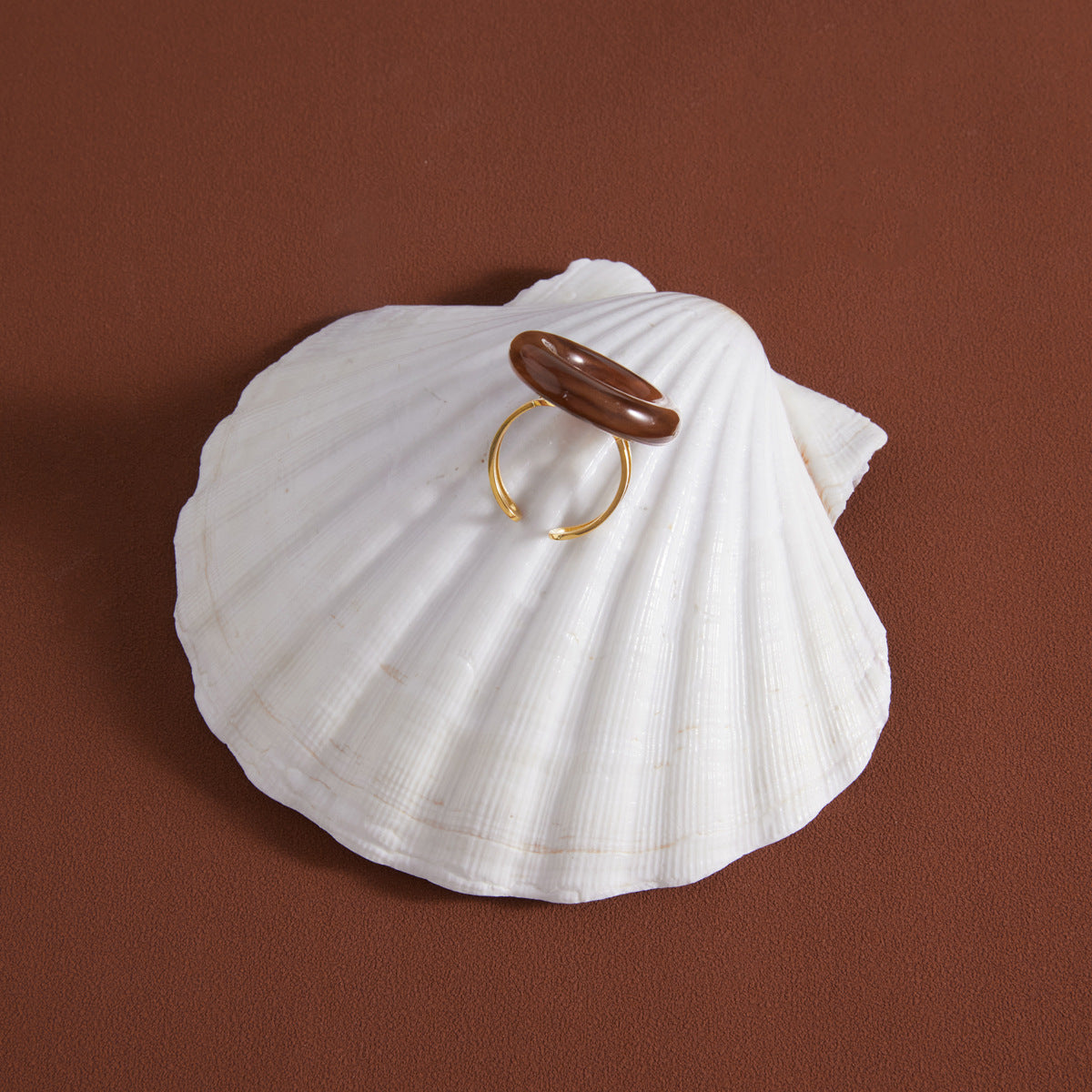 Side view of brown acrylic disc and open ring band