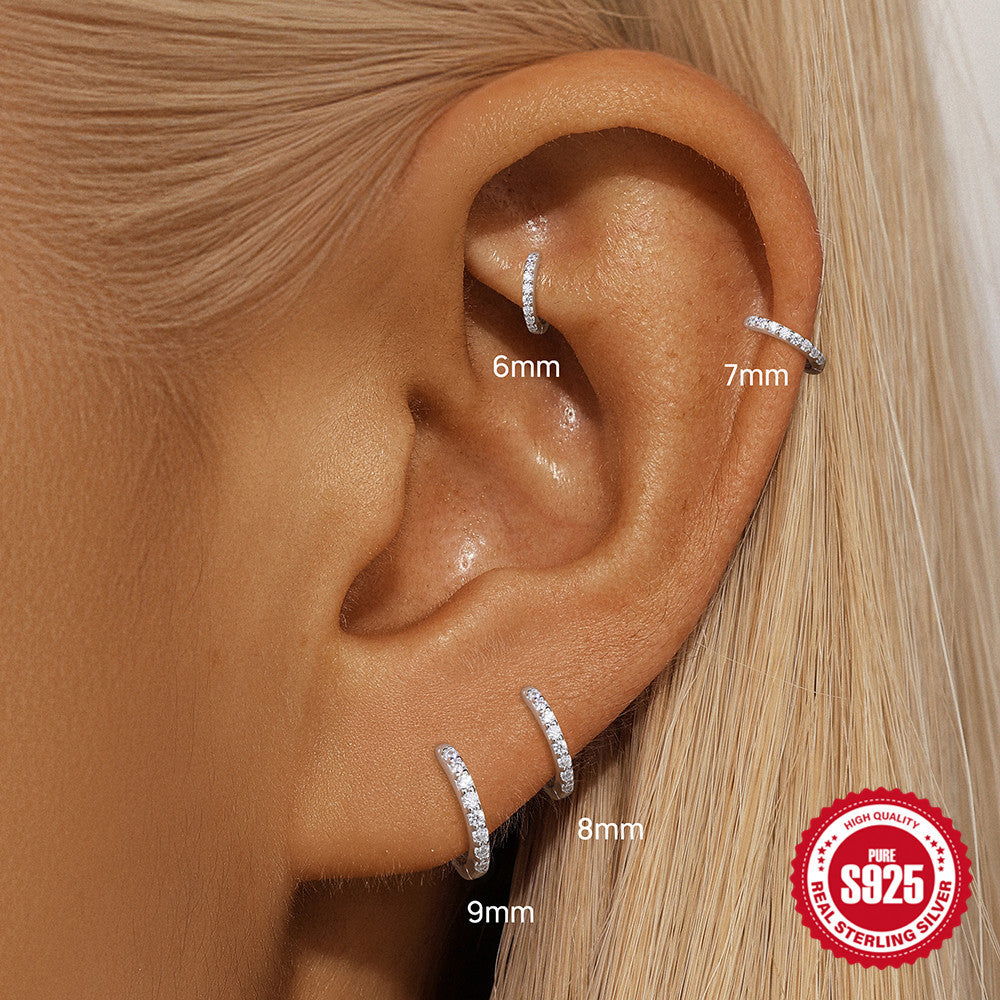 6, 7, 8 and 9 mm moissanite huggies placed along an ear stack