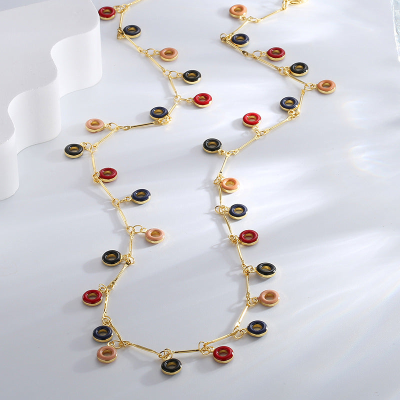multicolor resin ring charm necklaces arranged on a clear display