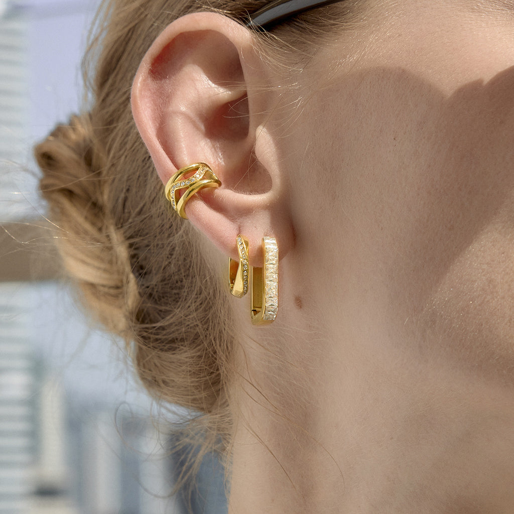 Gold tone stone-lined hoops styled on an ear