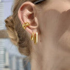 Gold tone stone-lined hoops styled on an ear