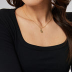 model wearing the delicate gold plated feather pendant necklace