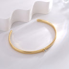 slim gold plated heart-set cuff bracelet in an angled view