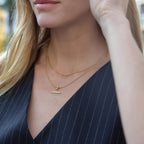 Clear-stone T-bar necklace shown on a model