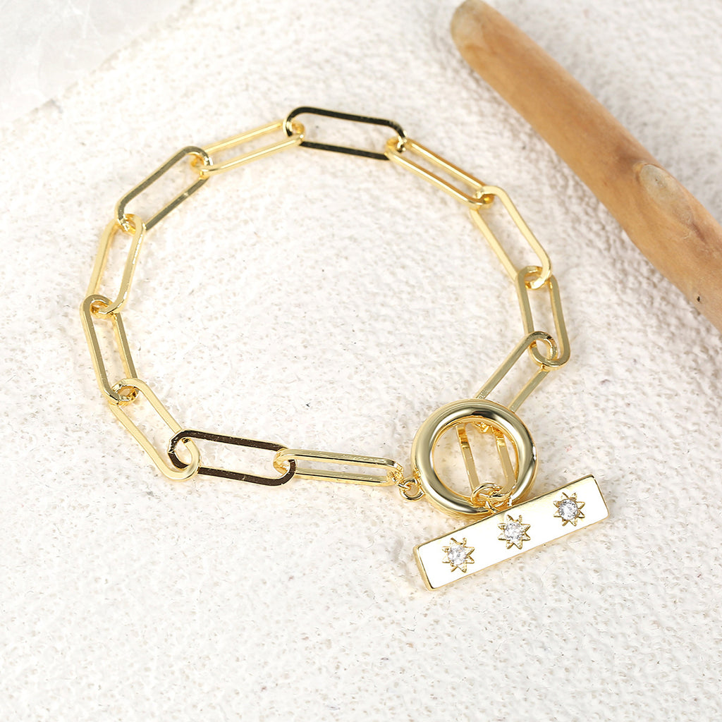 gold plated toggle link bracelet on a textured surface