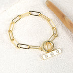 gold plated toggle link bracelet on a textured surface