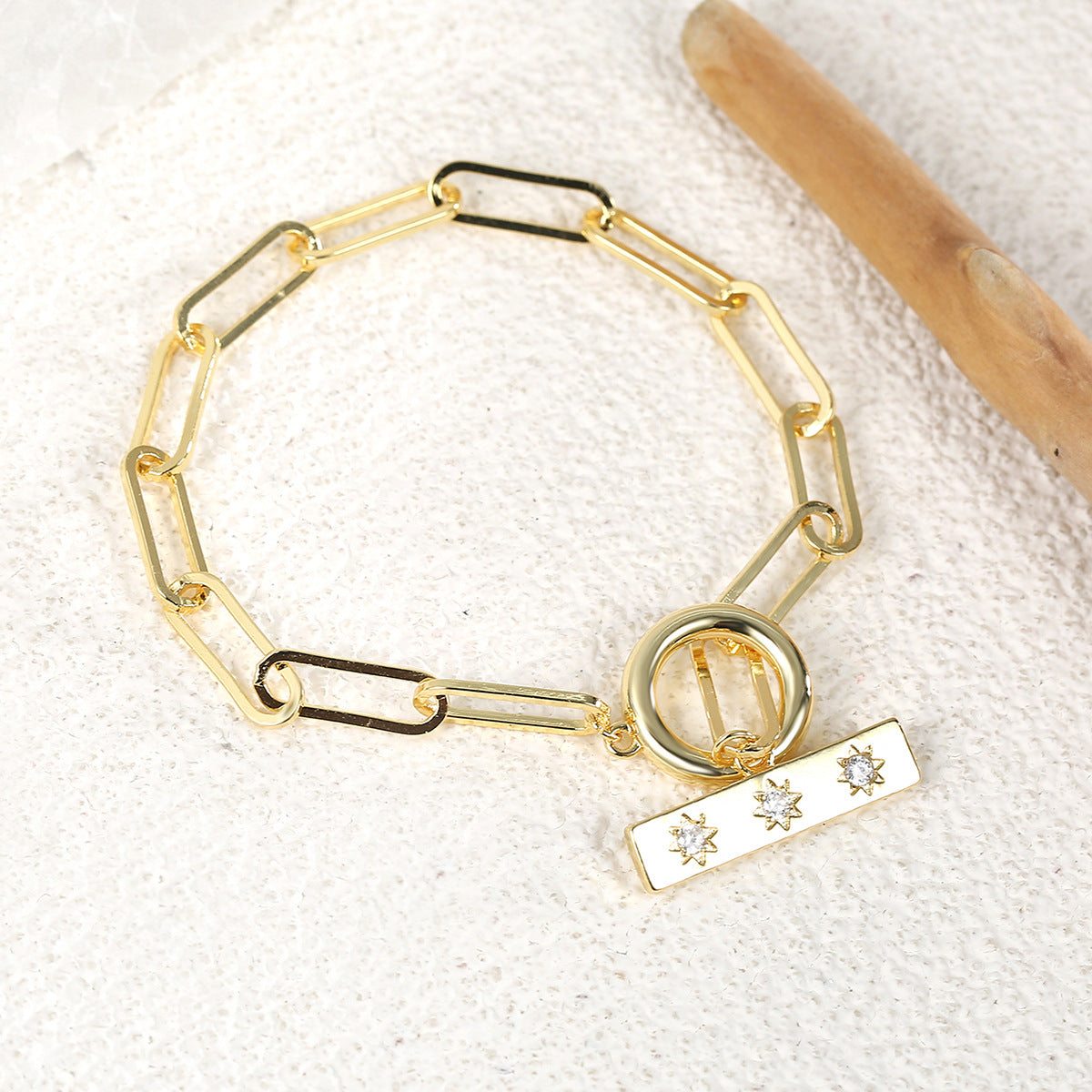 gold plated toggle link bracelet on a textured surface