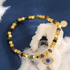 multicolor Indian agate evil eye bracelet on a blue display