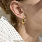 Gold-tone sculptural hoop shown on the ear