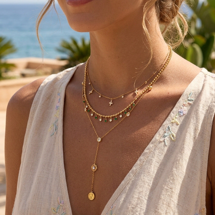 Gold-tone charm and fringe necklaces on a model