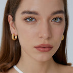 wide woven gold plated hoop earrings worn on the ear