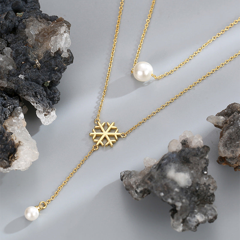snowflake shell pearl necklace arranged between dark mineral stones
