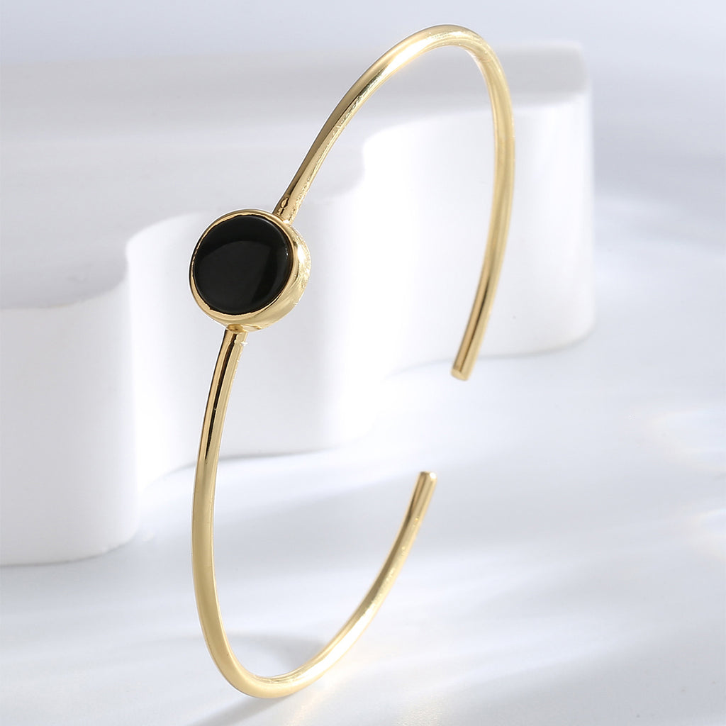 upright view of slim gold plated black agate open bangle