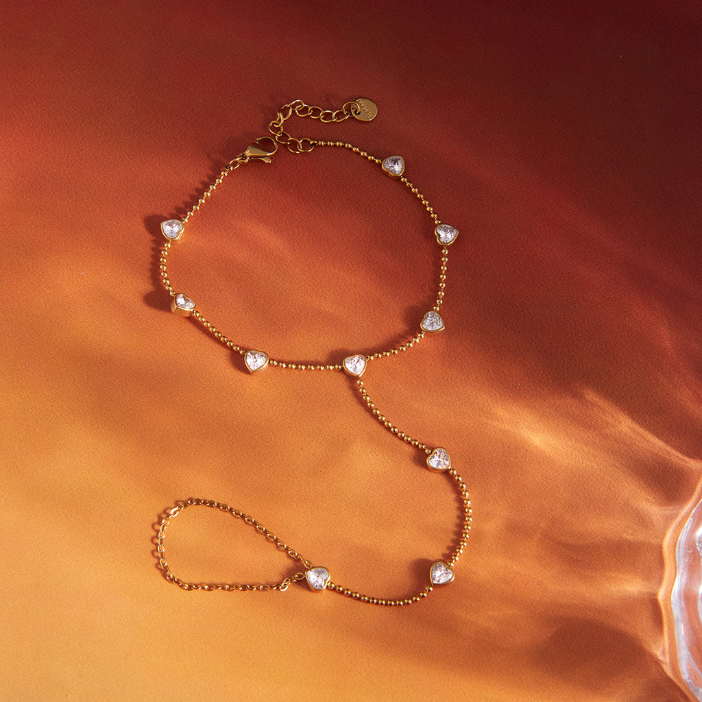 Complete clear stone hand chain on orange fabric