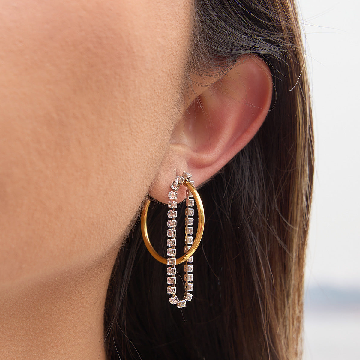 two-tone clear stone chain tassel hoop earrings worn on ear