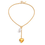 Full view of gold plated heart locket and white drop necklace