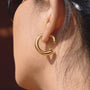 gold plated stainless steel open hoop earring worn on ear