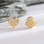 rounded clear zirconia heart studs arranged beside gray stone