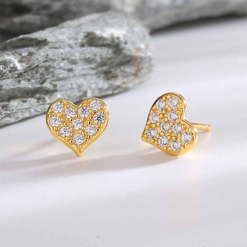 rounded clear zirconia heart studs arranged beside gray stone
