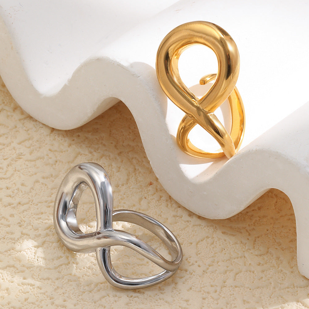gold and silver sculptural infinity rings displayed by a white form