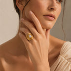 Gold plated white pearlescent ring worn on a model's hand