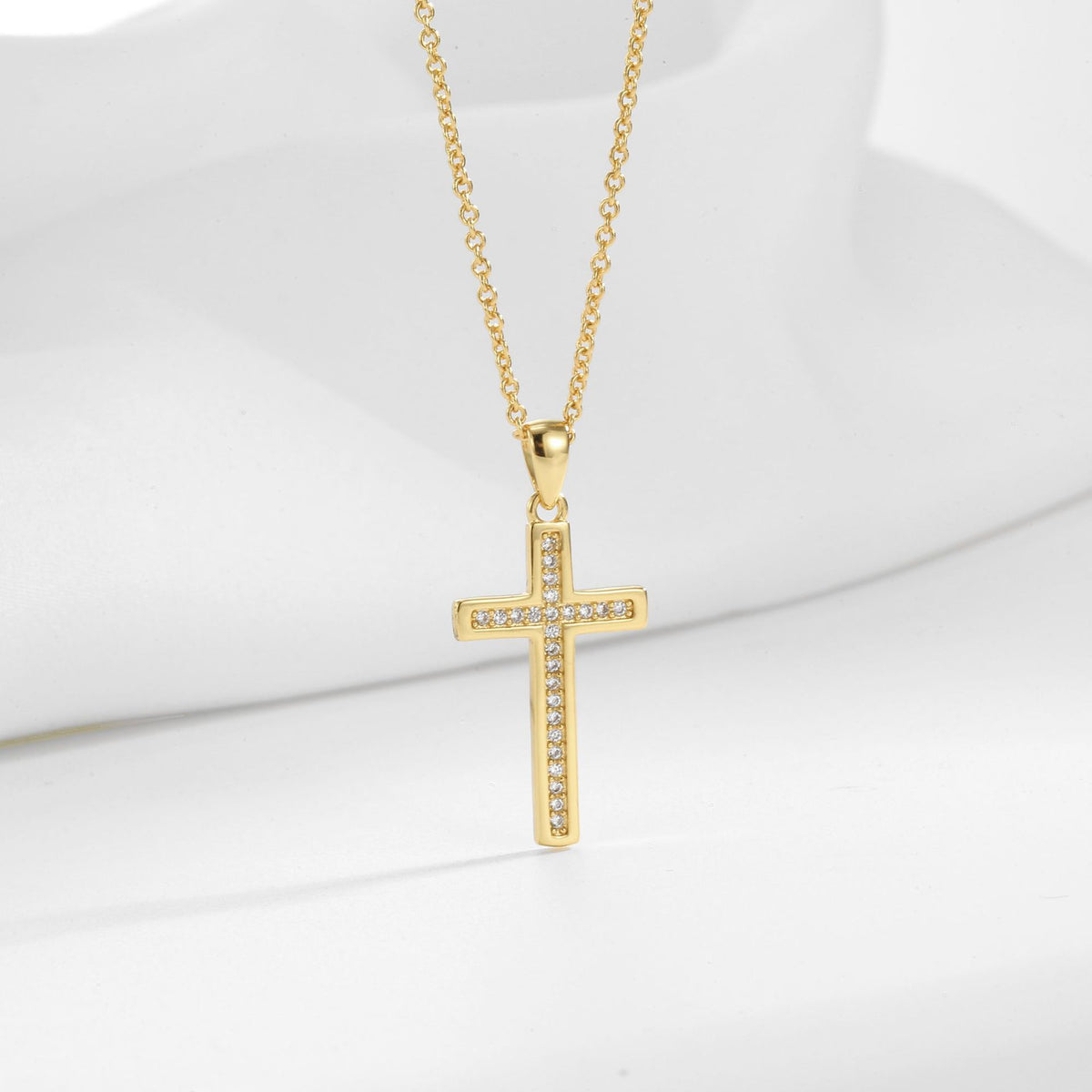 cross pendant with narrow inset stone row on gold plated chain