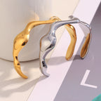 gold plated and silver-finish stainless steel wave cuffs displayed together