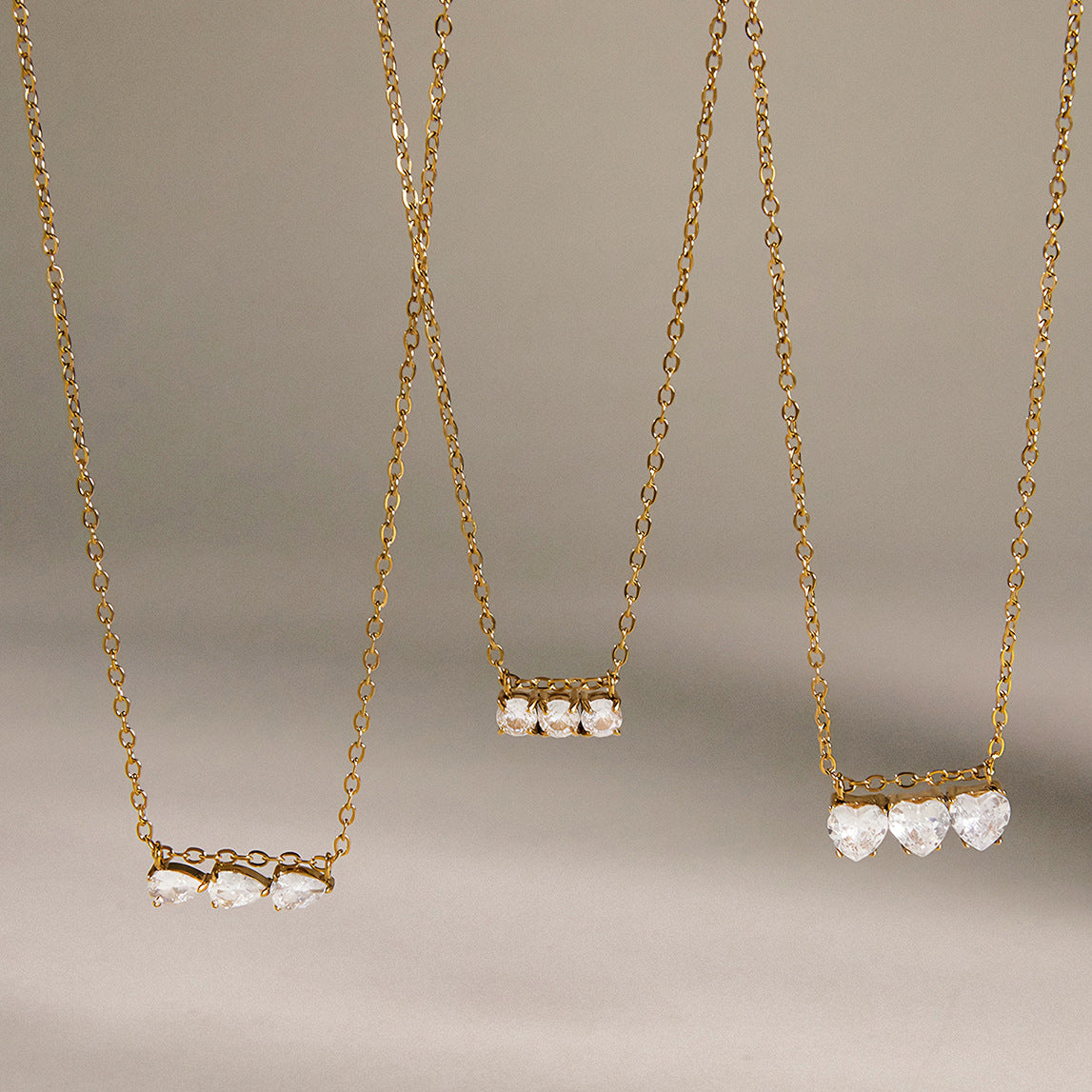 Triple-stone pendants hanging at different display heights