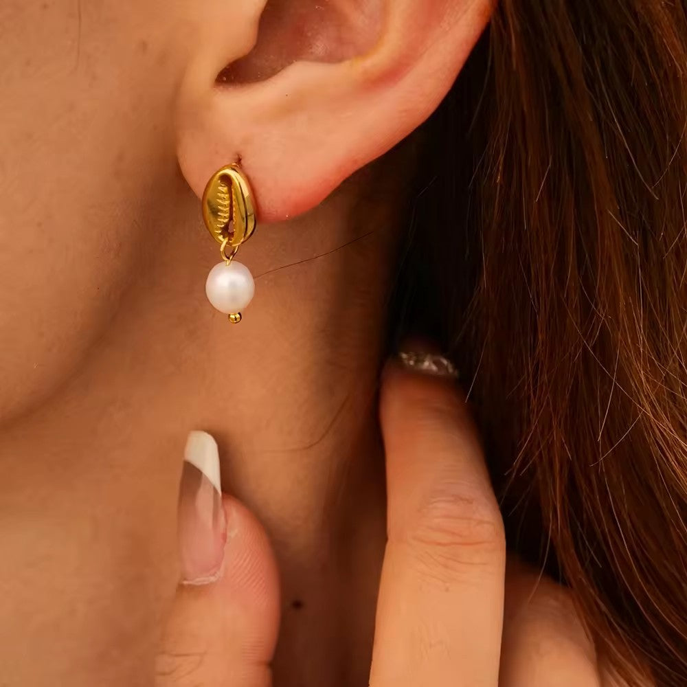 Gold-tone white bead drop earrings worn view