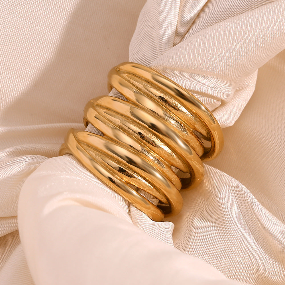 overlapping polished ring bands styled on cream satin