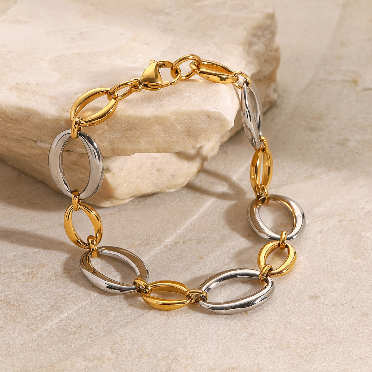 Alternating large and small link bracelet on stone props