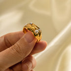 Close-up of the white beads and flowing ring surface held by hand