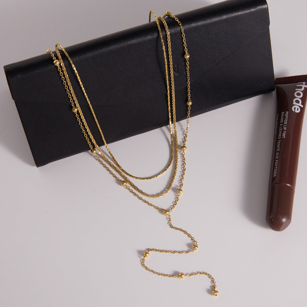 Layered fine chains displayed on a black accessory