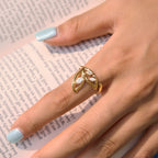 Gold tone botanical ring worn over an open book