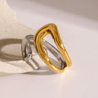 Angled view of the gold plated open loop and silver-colored ring band