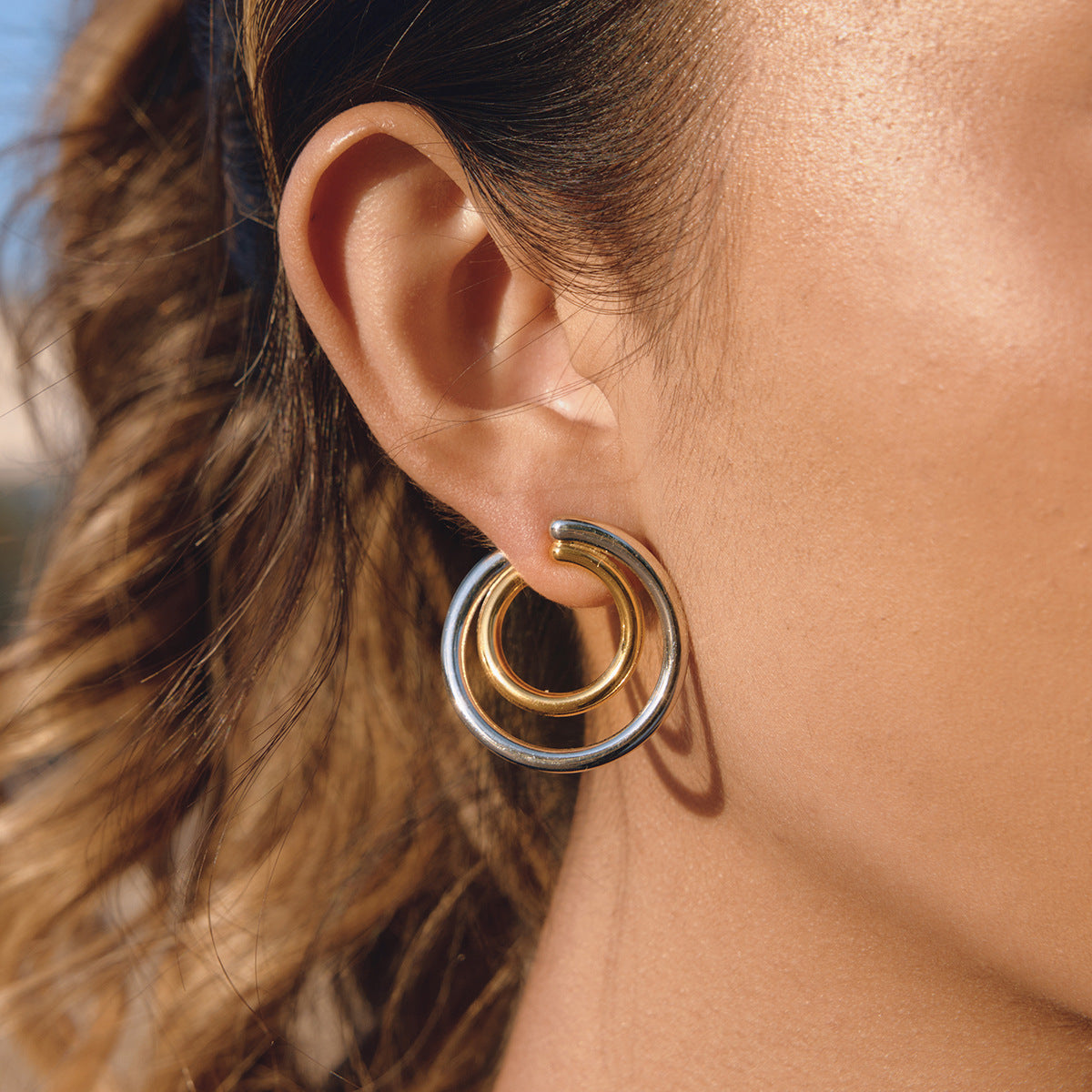Two-tone nested double hoop stainless steel earring shown worn
