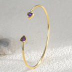 upright view of slim gold plated purple stone open cuff